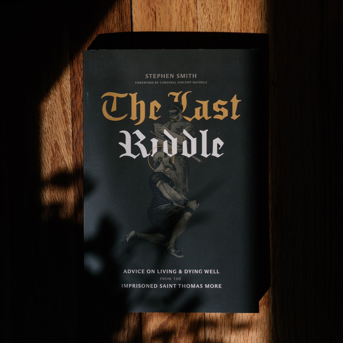 Book titled 'The Last Riddle' by Stephen Smith on a wooden surface